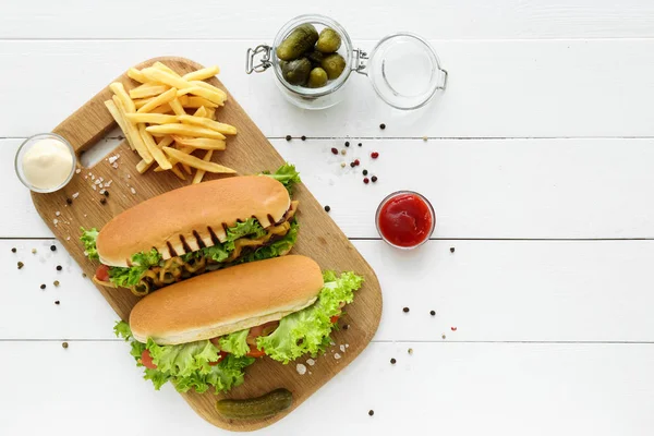 Tasty hot dogs with french fries on white table — Stock Photo, Image