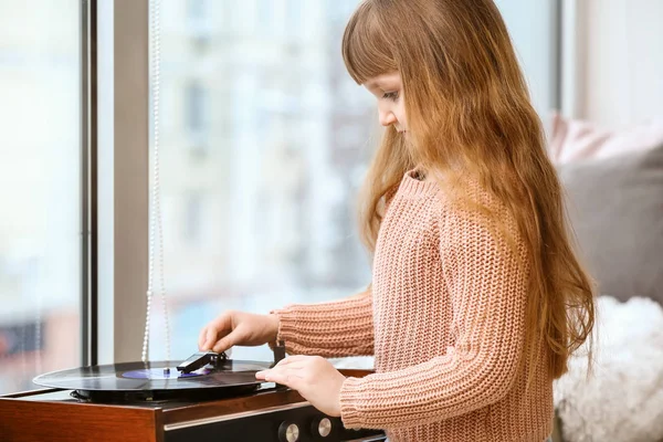 Linda niña escuchando música a través de tocadiscos en casa — Foto de Stock