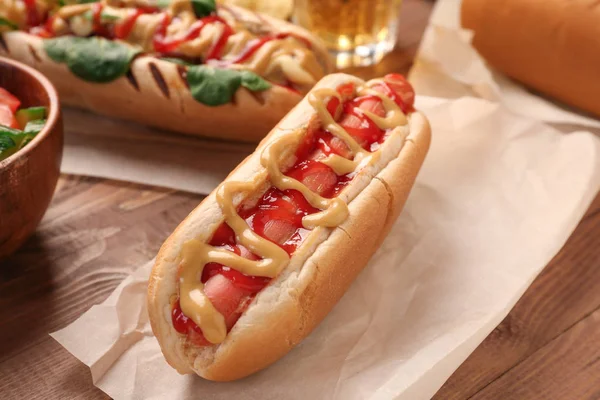 Tasty hot dog on wooden table — Stock Photo, Image