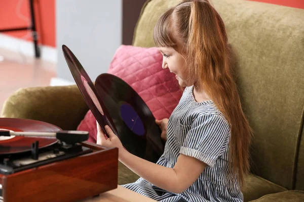 Linda niña escuchando música a través de tocadiscos en casa — Foto de Stock
