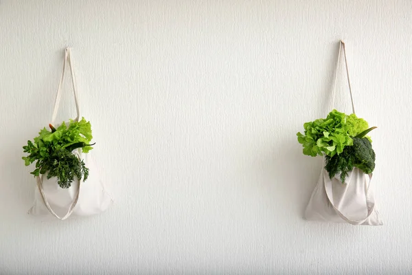 Eco torbaları ile taze sebze duvarda asılı