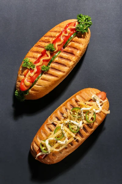 Smaczne hot dogi na ciemnym tle — Zdjęcie stockowe