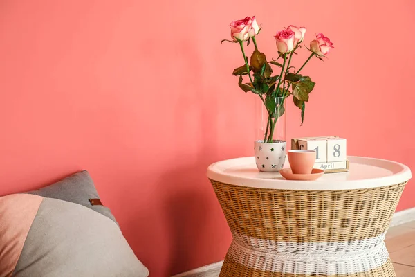 Verse rozen met kop koffie en kalender op tafel in de buurt van kleur muur — Stockfoto