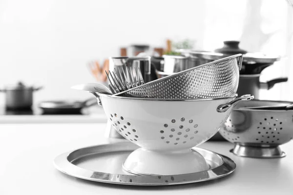 Colanders and tray on kitchen table — Stock Photo, Image