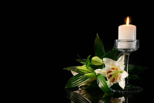 Горящие свечи и цветы на черном фоне — стоковое фото