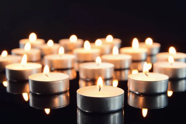 Molte candele accese come simbolo di lutto su sfondo scuro — Foto Stock