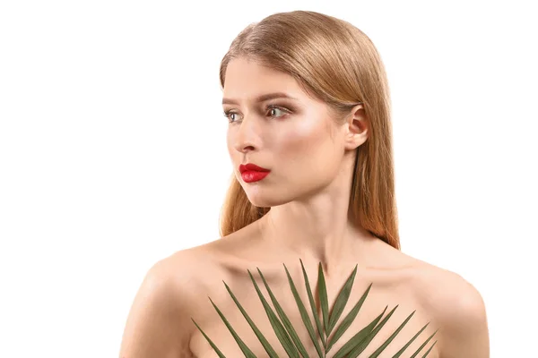 Mooie jonge vrouw met lichte make-up en tropische leaf op witte achtergrond — Stockfoto