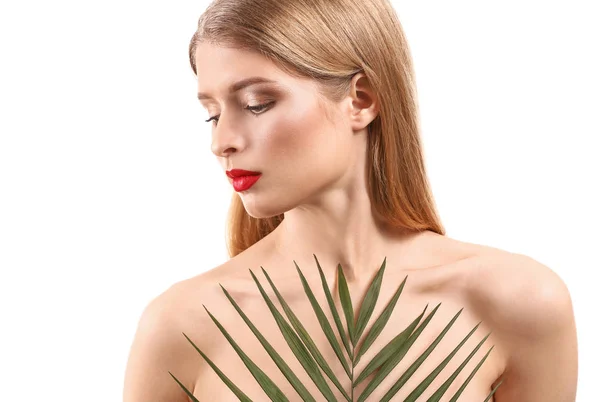 Mooie jonge vrouw met lichte make-up en tropische leaf op witte achtergrond — Stockfoto