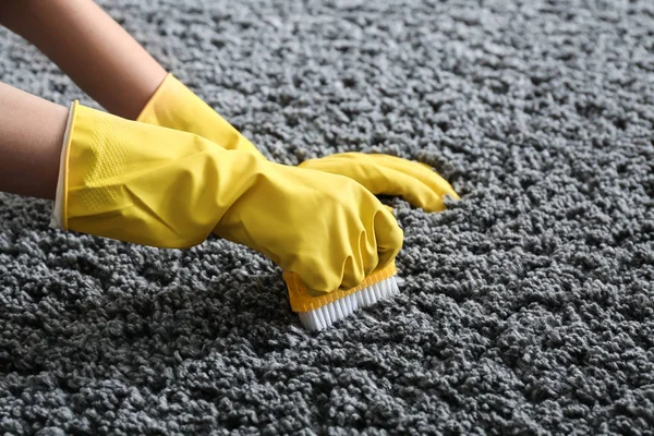 Woman cleaning carpet at home