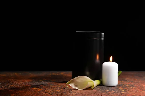 Mortuarium urn, brandende kaars en bloemen op tafel tegen de donkere achtergrond — Stockfoto