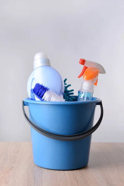 Set of cleaning supplies on table against light background — Stock Photo, Image