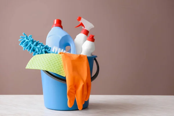 Set of cleaning supplies on table against color background — Stock Photo, Image