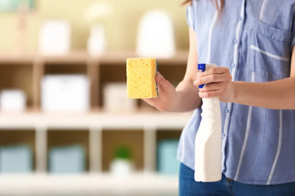 Vrouw met fles afwasmiddel en een spons op kamer — Stockfoto