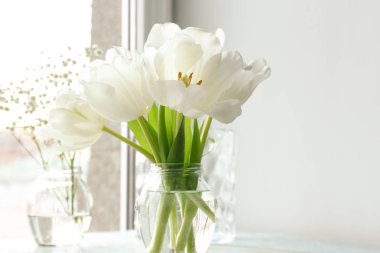 Pencere yakınındaki masaya güzel çiçek ile jar