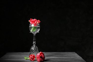 Koyu arka plan karşı masaya güzel çiçek ile kompozisyon