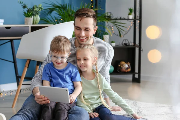 Young father with little children watching cartoons at home — Stock Photo, Image