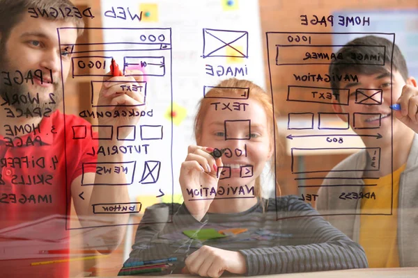 IT designers discussing project, view through transparent board — Stock Photo, Image