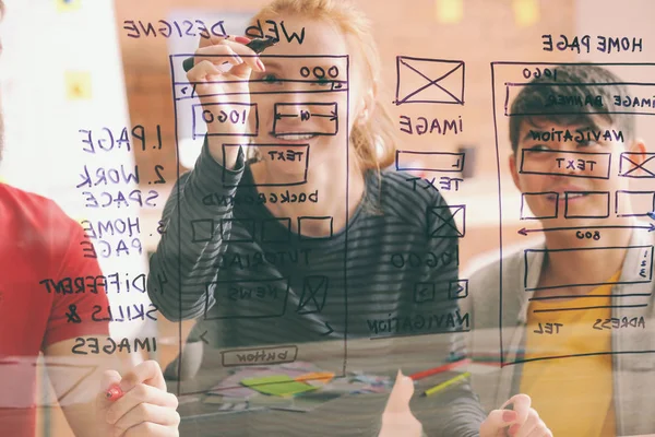 IT designers discussing project, view through transparent board — Stock Photo, Image