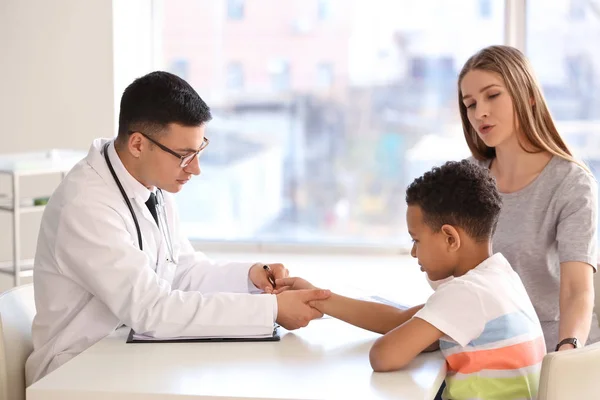 Pediatra examinando menino afro-americano na clínica — Fotografia de Stock