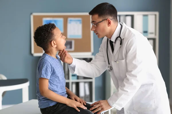 Pediatra examinando menino afro-americano na clínica — Fotografia de Stock