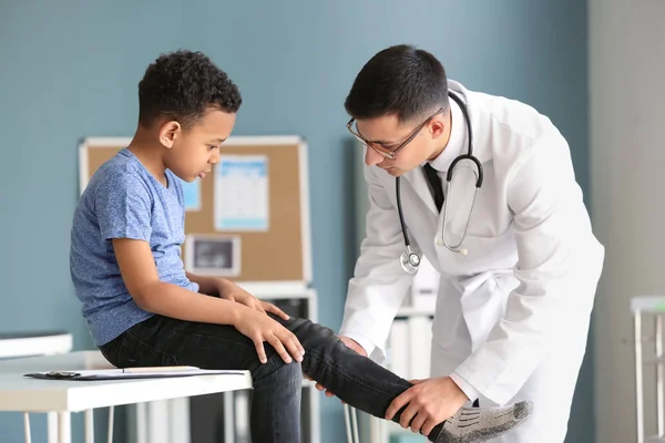 Pediatra examinando menino afro-americano na clínica — Fotografia de Stock