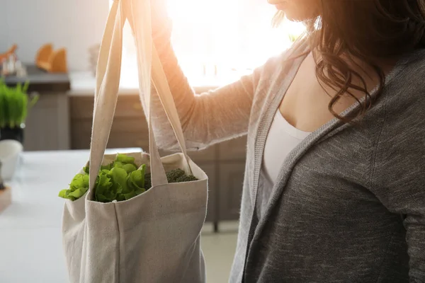 エコバッグを屋内で新鮮な野菜を持つ若い女性 — ストック写真