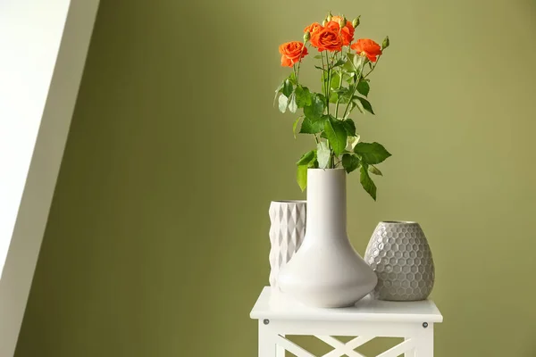 Vases with beautiful flowers on table in room — Stock Photo, Image