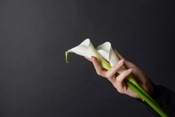 Woman with funeral flowers on dark background — Stock Photo, Image
