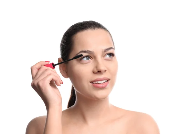 Mooie jonge vrouw met wimper extensions toepassing van mascara op witte achtergrond — Stockfoto