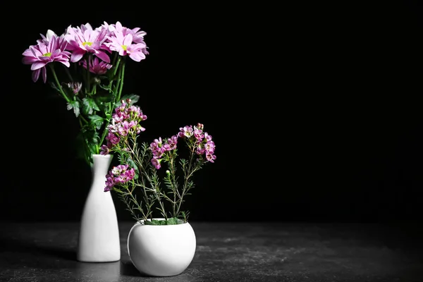 Vaser med vackra blommor på mörk bakgrund — Stockfoto