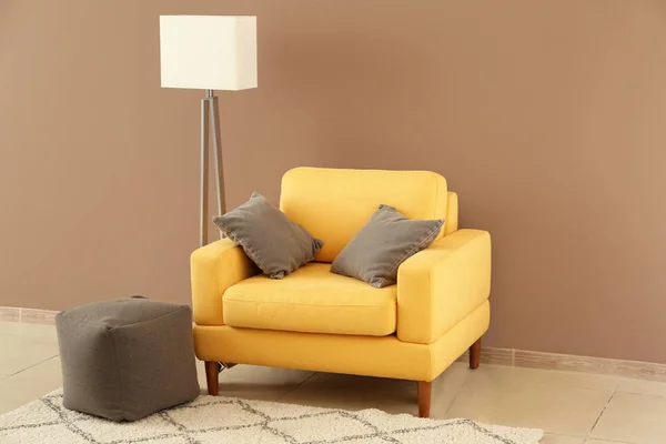 Soft armchair with floor lamp near color wall in room — Stock Photo, Image