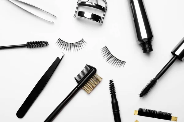 Mascara with false eyelashes and tools on white background — Stock Photo, Image