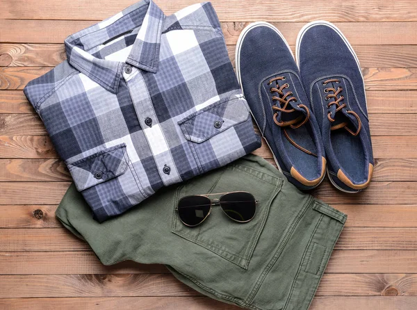 Ropa masculina con gafas de sol sobre fondo de madera — Foto de Stock