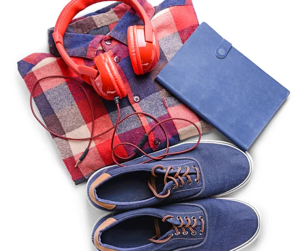 Camisa com sapatilhas, fones de ouvido e notebook sobre fundo branco — Fotografia de Stock