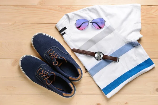 Camiseta con zapatillas y accesorios sobre fondo de madera — Foto de Stock