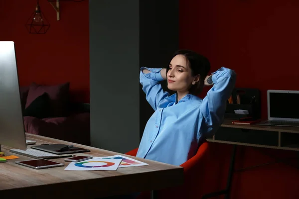 Designer feminino descansando depois de trabalhar no escritório no final da noite — Fotografia de Stock