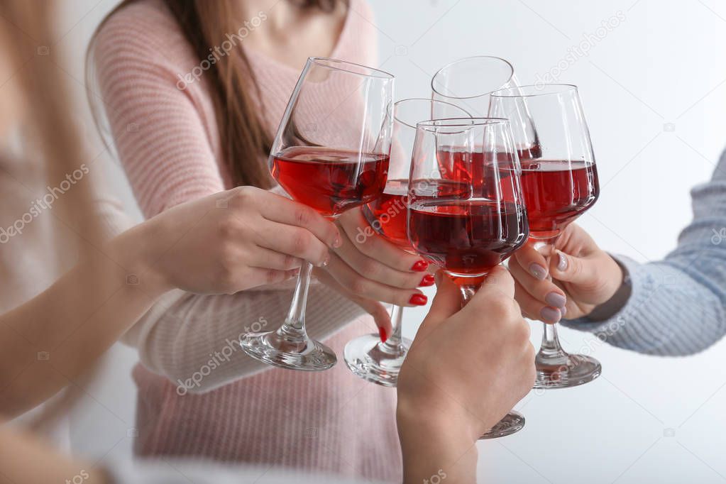 Friends clinking glasses with tasty wine at party