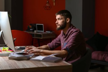 Gece geç saatlerde ofiste çalışan erkek tasarımcı