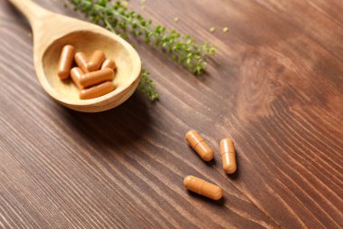 Bitki kaşıkla hapları üzerinde ahşap arka plan dayalı.