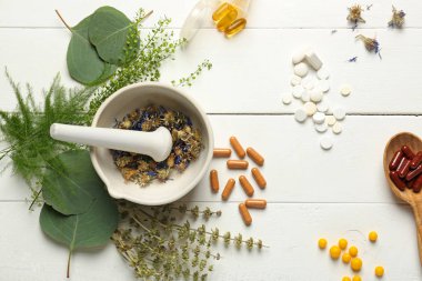 Harç, otlar ve bitki kompozisyonu hapları Beyaz ahşap zemin üzerine dayalı.