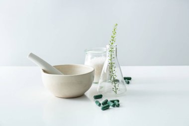 Harç, şişesi ve bitki kompozisyonu hapları tabloyu temel alan.