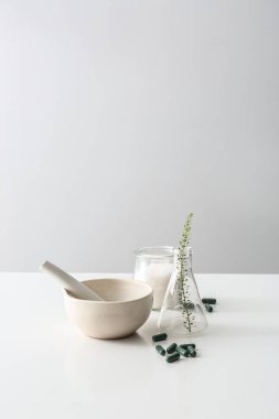 Harç, şişesi ve bitki kompozisyonu hapları tabloyu temel alan.