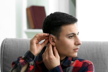 İşitme cihazı evde olan genç adam