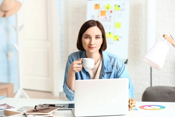 Kvinnliga formgivare kaffedrickande medan arbetande i kontor — Stockfoto