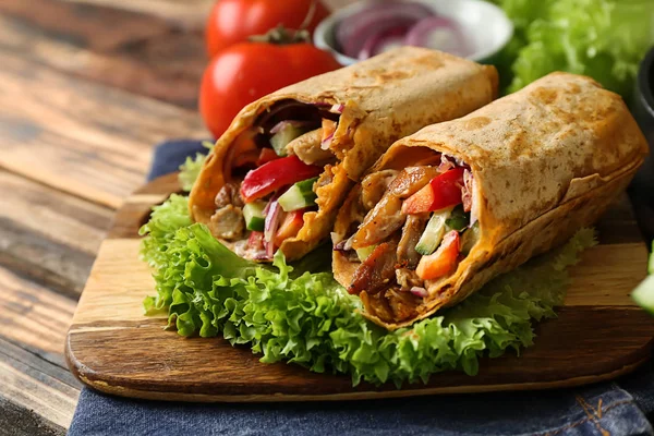 Board with tasty doner kebab on table — Stock Photo, Image