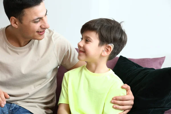 Young man and his son with hearing aid at home — Stock Photo, Image