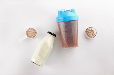 Protein içeceği ve beyaz arka plan üzerinde süt şişeleri
