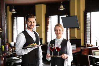 Restoranda şarap ve salata ile genç Garsonlar