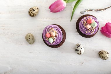 Tatlı Paskalya kek, bıldırcın yumurtası ve çiçek Beyaz ahşap zemin üzerinde