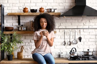 Afrikalı-Amerikalı kadın mutfakta kahve içme